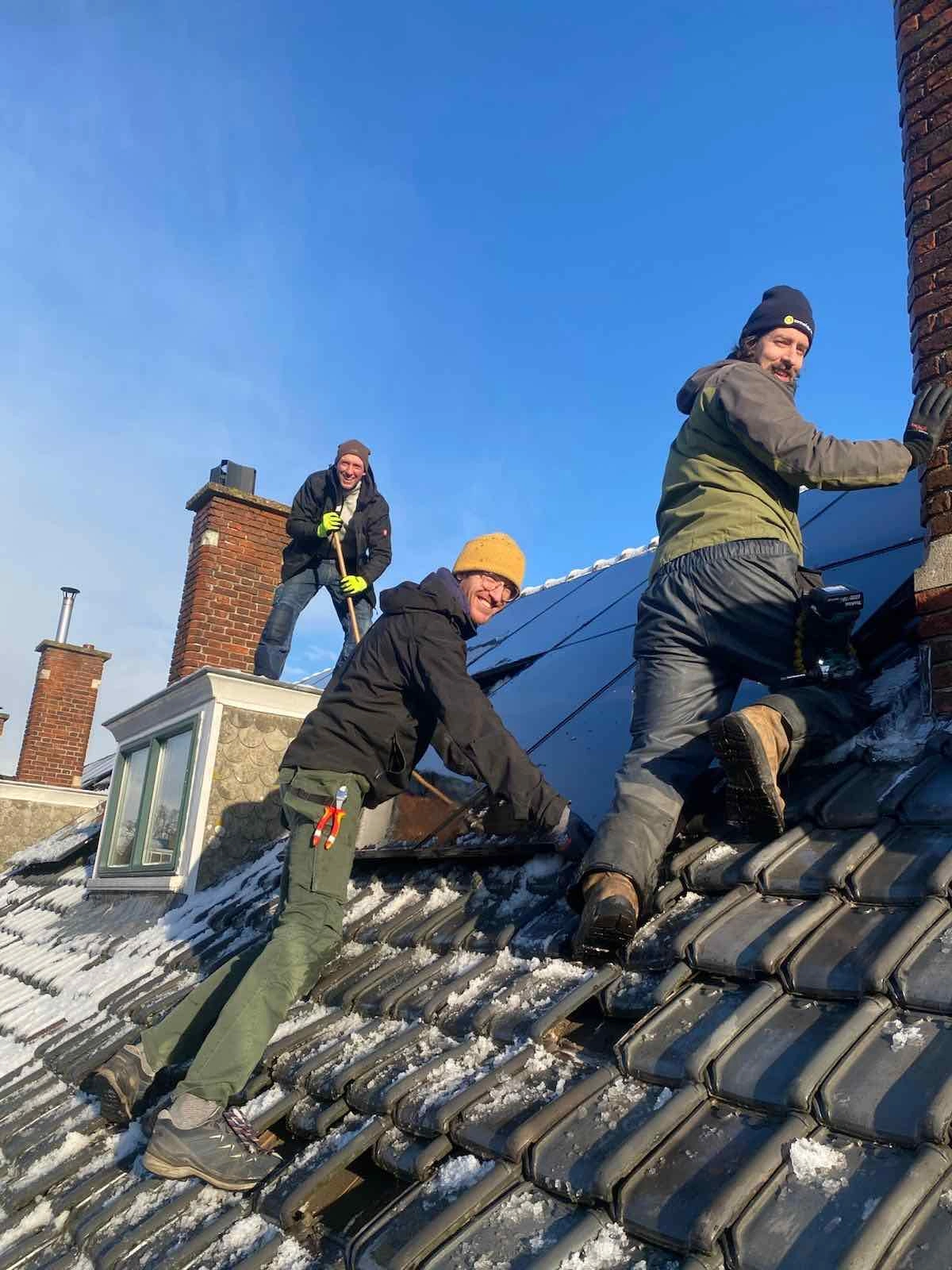 monteurs op dak met sneeuw